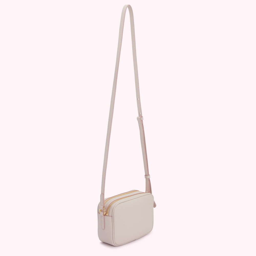 Light beige rectangular crossbody bag with a long strap and gold zippers.
