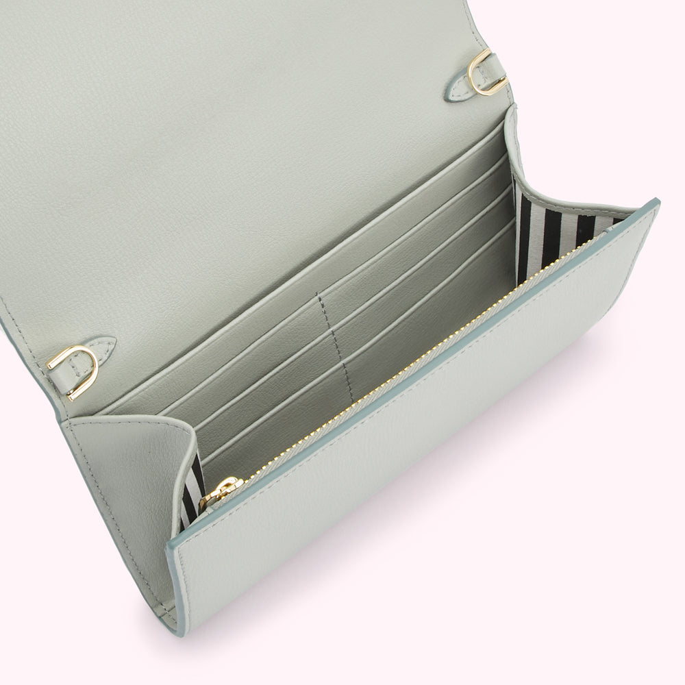 A light blue leather wallet with gold hardware, open to reveal multiple card slots and a zippered compartment. The interior lining is black and white striped.
