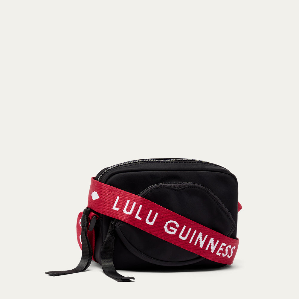 Black bag with a red strap featuring 'Lulu Guinness' on a white background