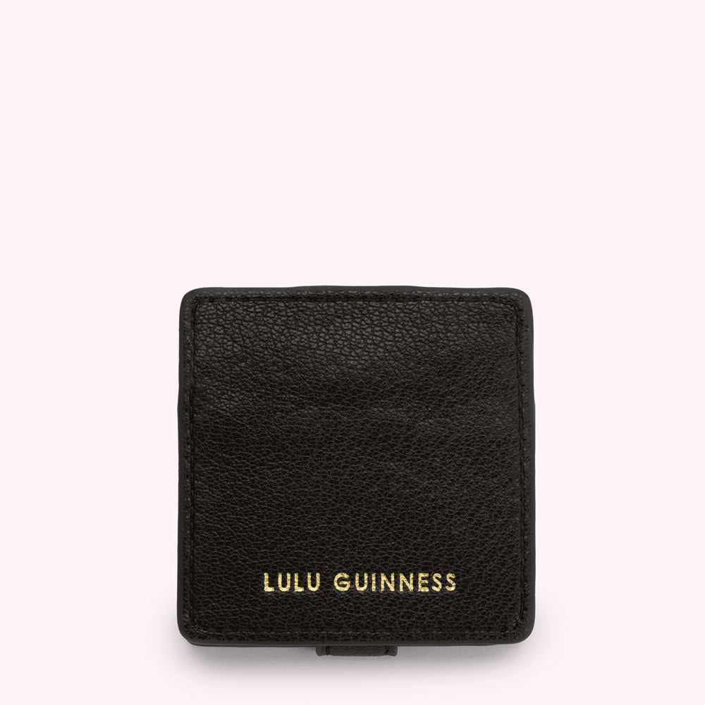 Black Lulu Guinness compact mirror against a white background.
