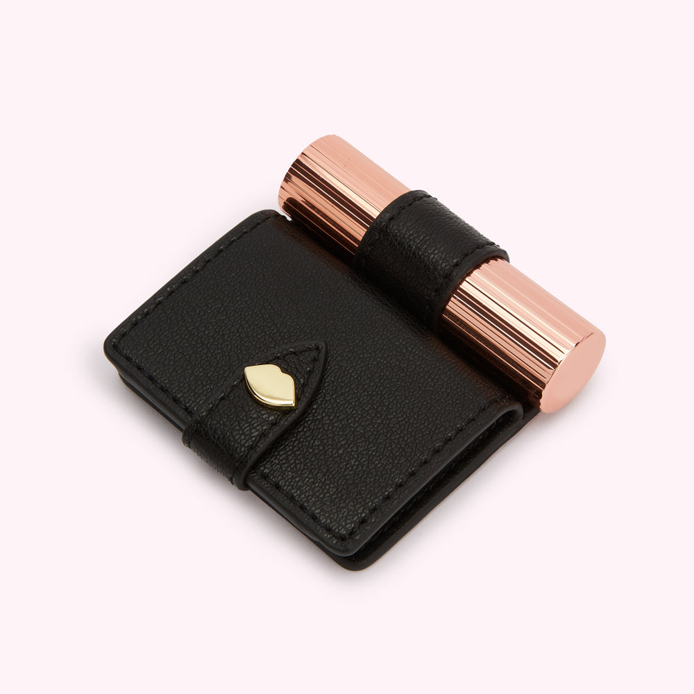Black leather compact mirror with a rose gold lipstick.
