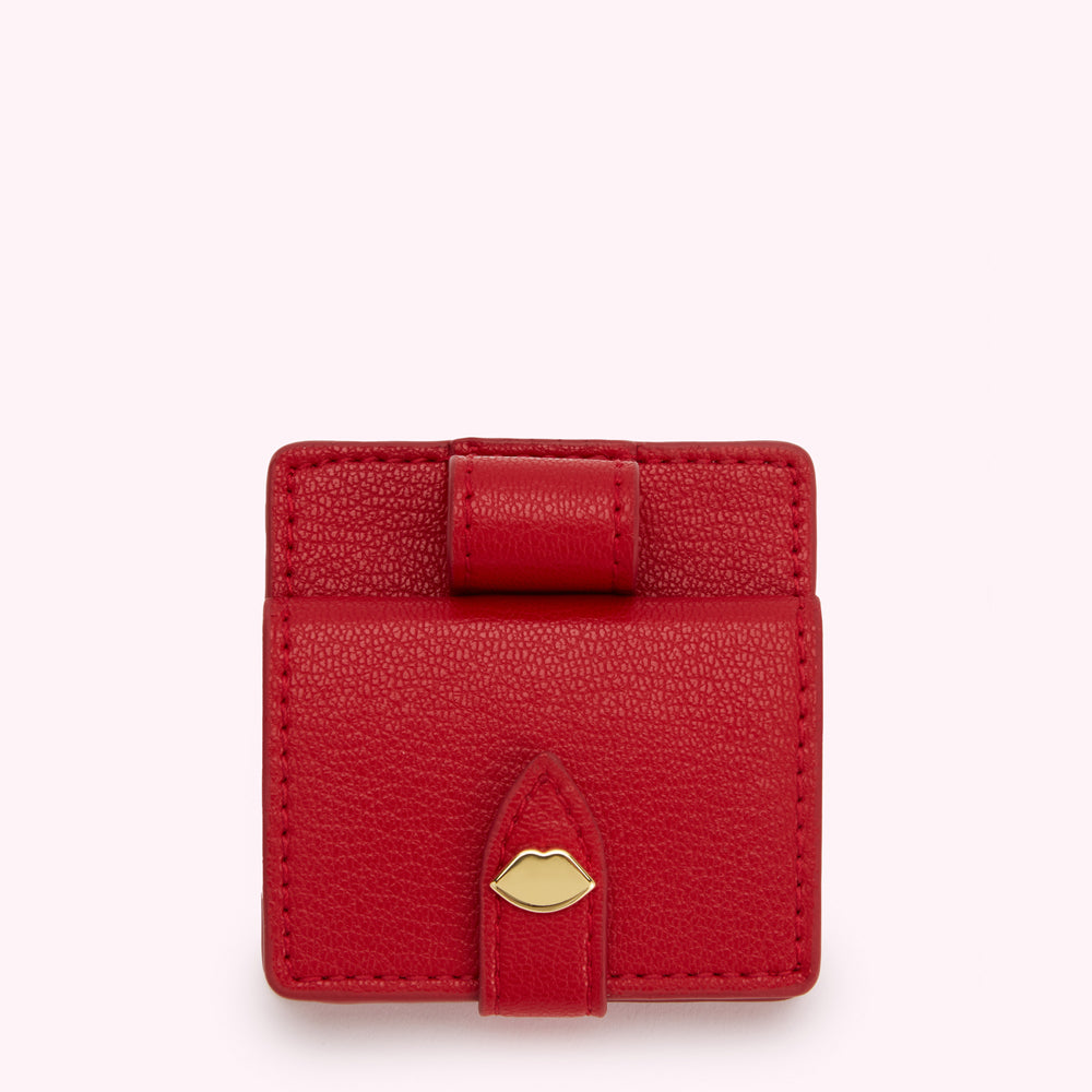 Red leather compact mirror and lipstick case with gold lip detail.
