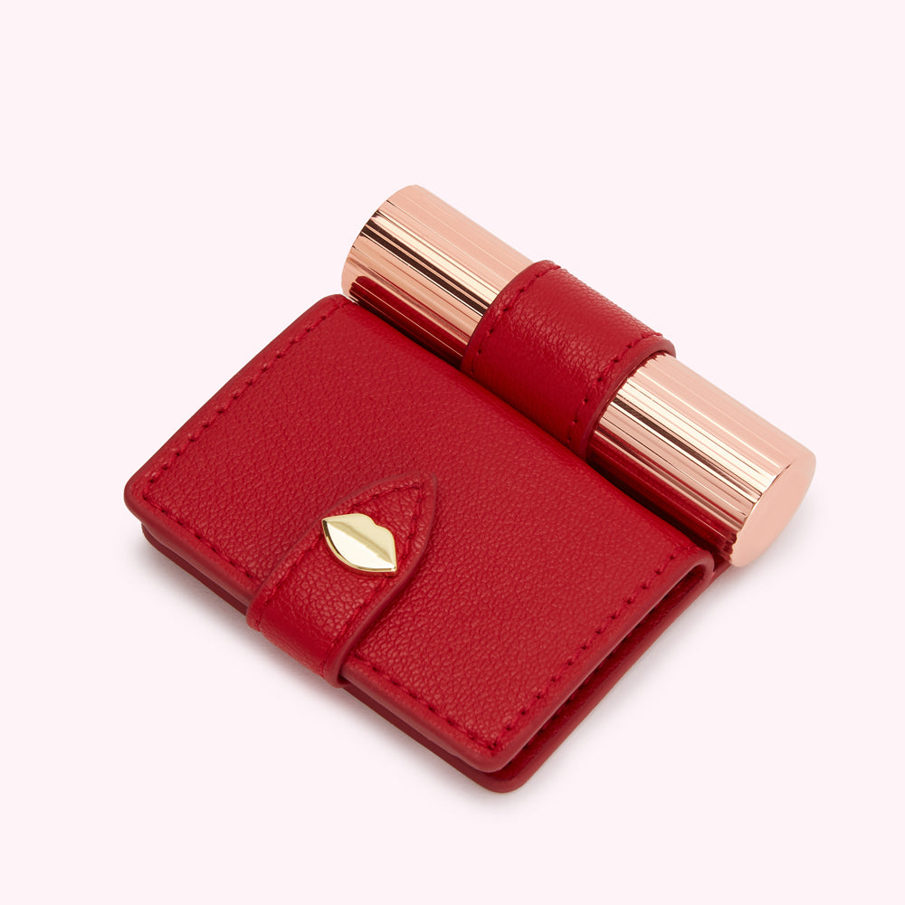 Red leather compact mirror and lipstick case with rose gold lipstick inside.
