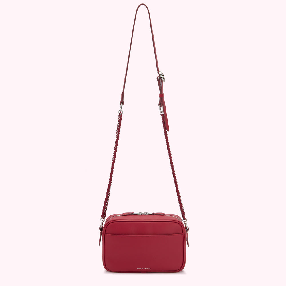 A red crossbody bag with a chain strap against a white background.
