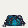A small crossbody bag with a dark navy blue leopard print pattern, featuring a central blue and teal jaguar graphic and a branded strap, shown on a light gray background.