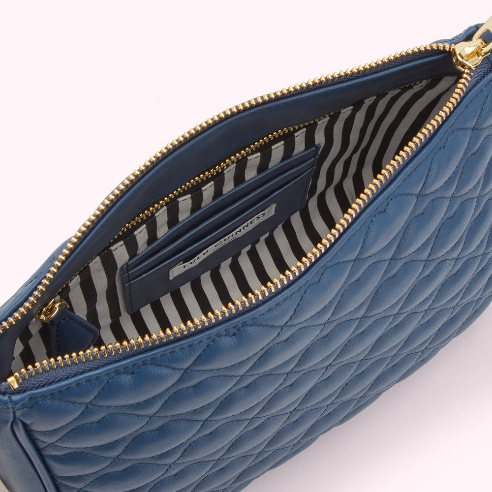 Open blue quilted leather Lulu Guinness purse with gold zipper and black and white striped interior lining.