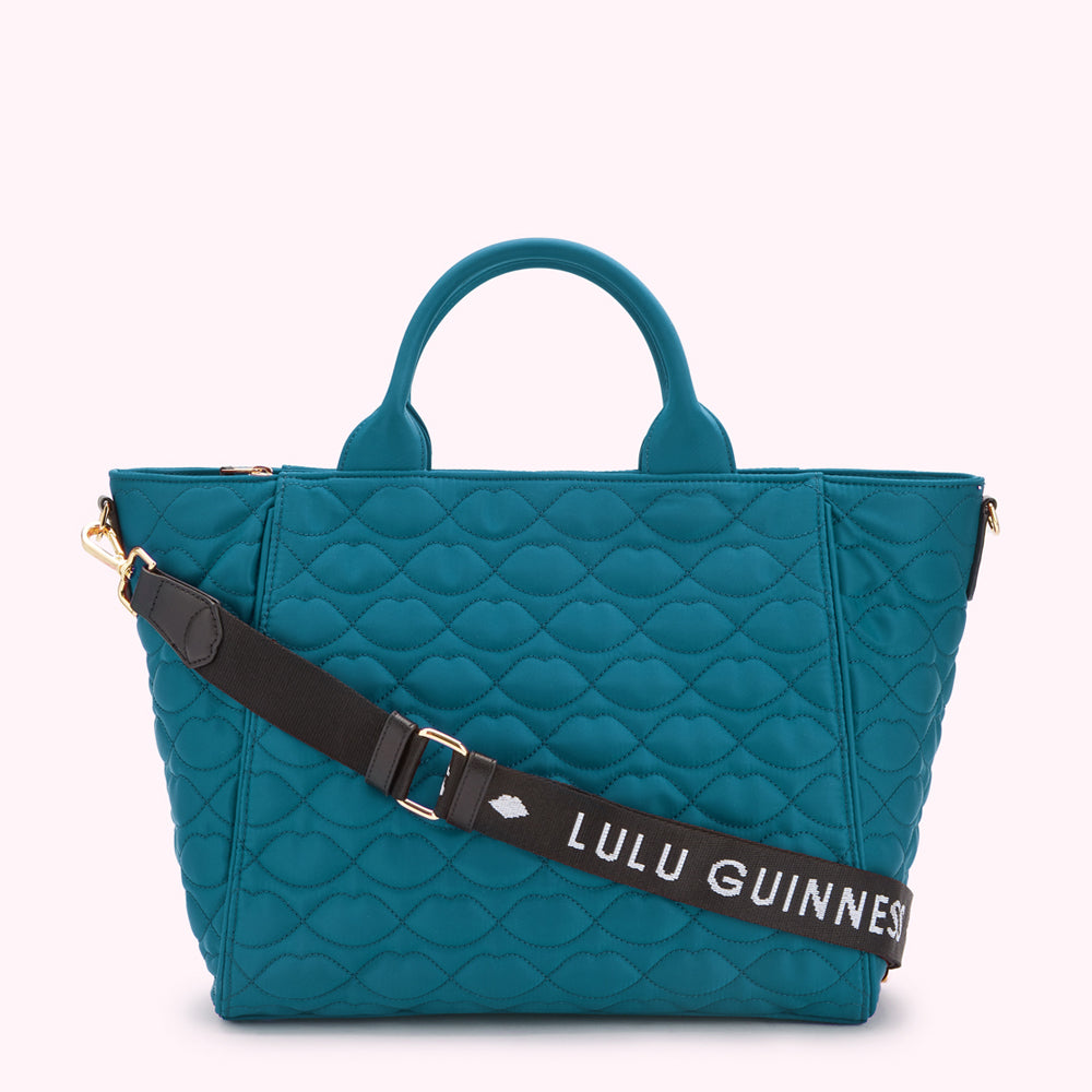Teal quilted Lulu Guinness tote bag with black crossbody strap.
