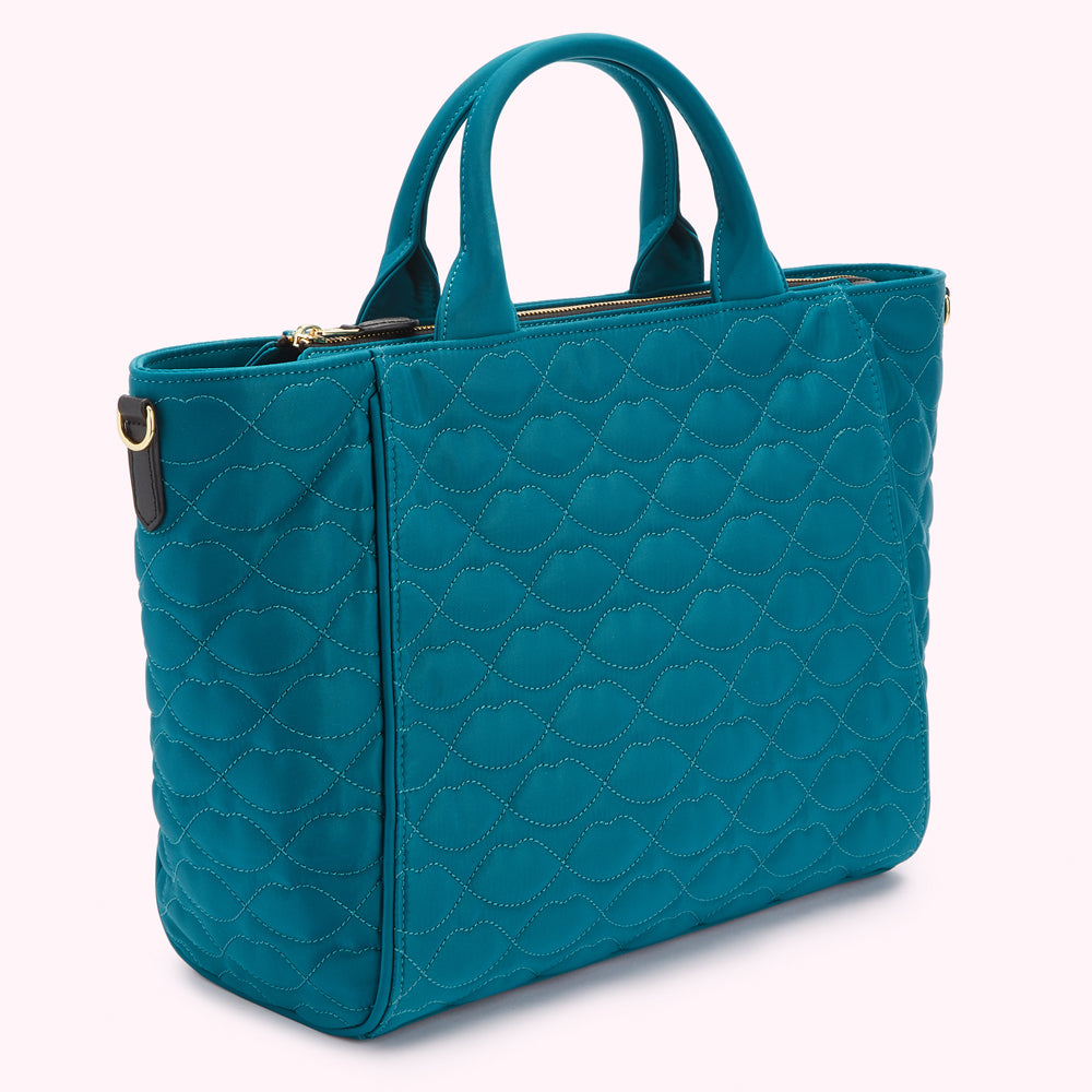 Teal quilted tote bag with top handles and zipper closure.
