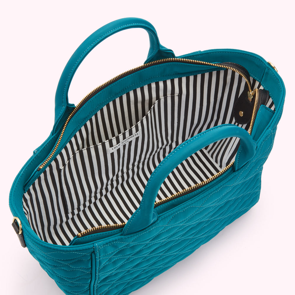 Teal quilted Lulu Guinness handbag with black and white striped interior lining.

