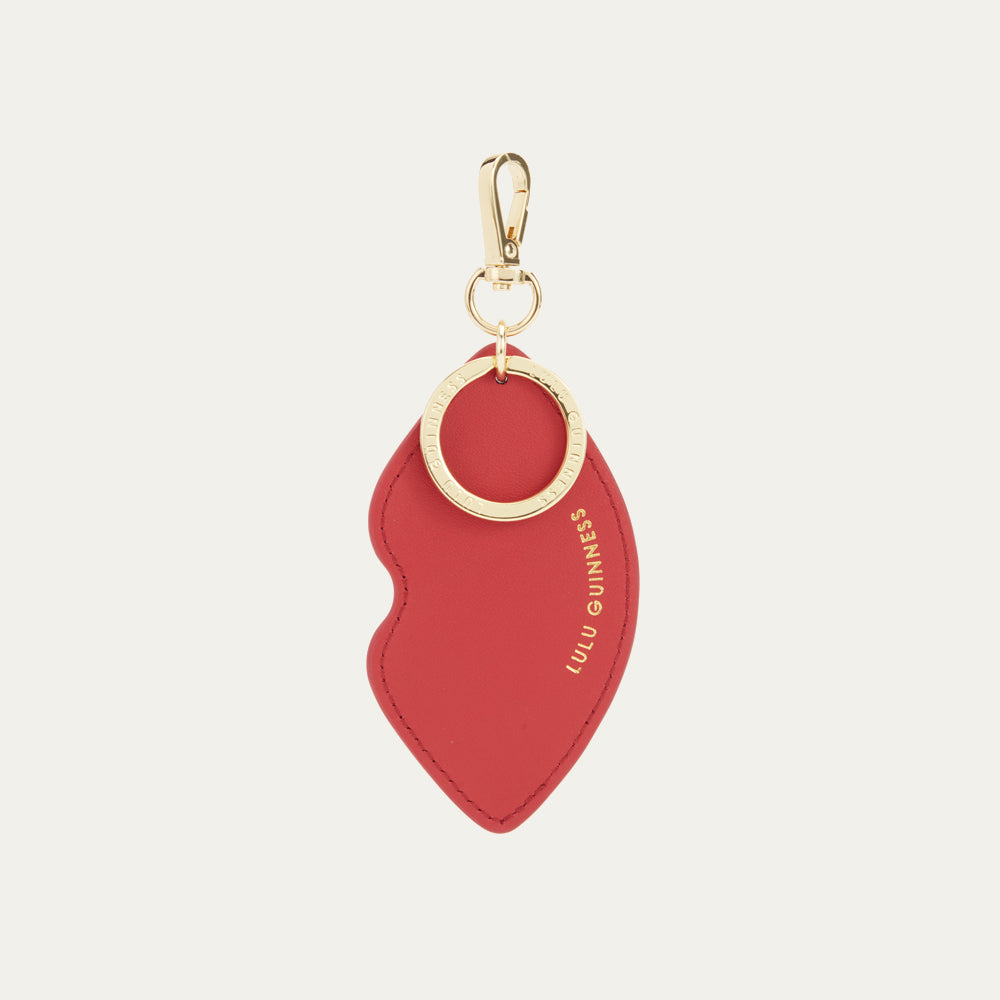 Back image of a red leather lip shaped keyring with gold foil print 'Lulu Guinness' logo and branded clip.