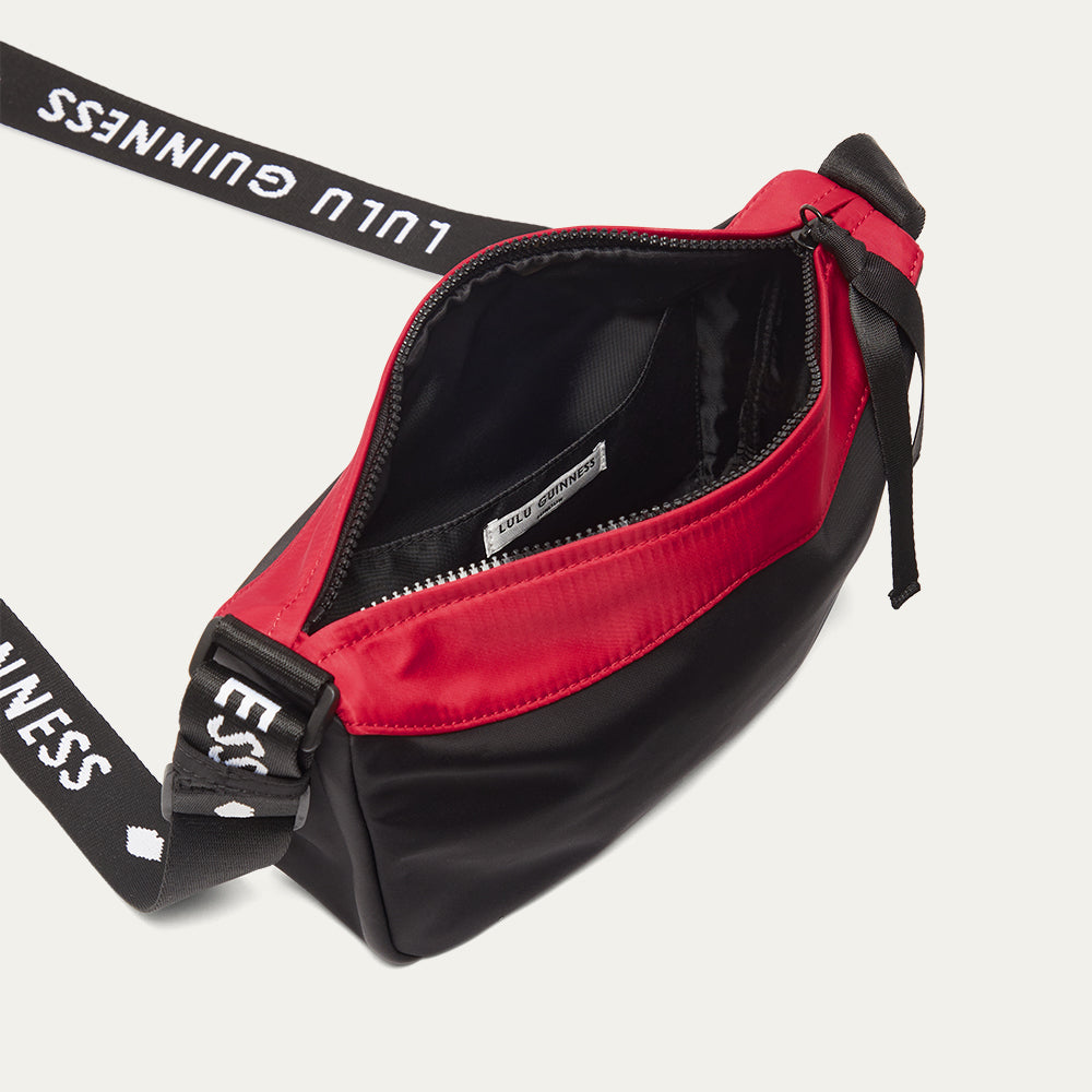 Red and black bag with a 'Lulu Guinness' branded strap on a white background