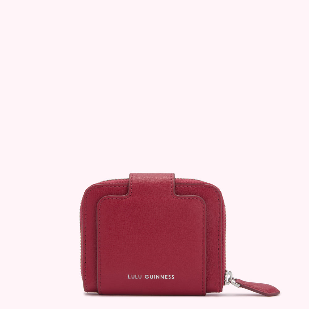 Red Lulu Guinness zip-around wallet against a white background.

