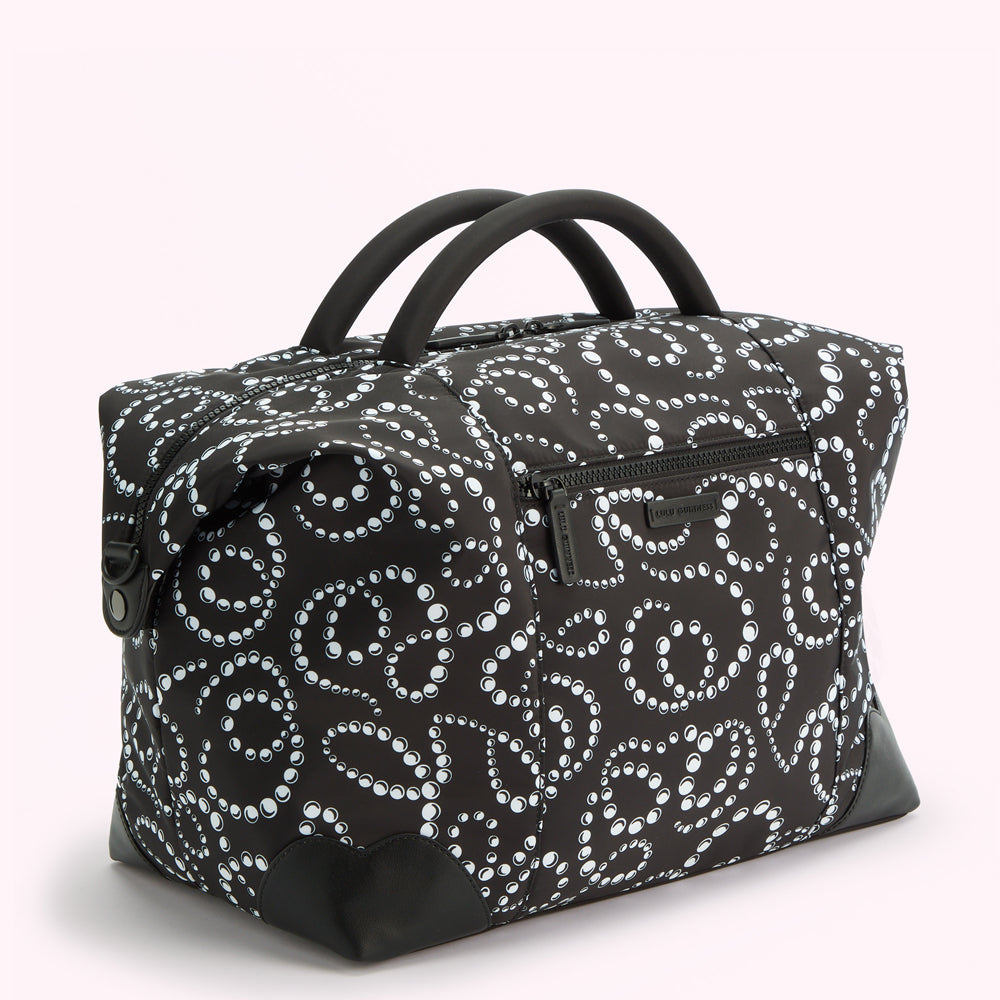 Black and white patterned duffel bag with black handles and accents.
