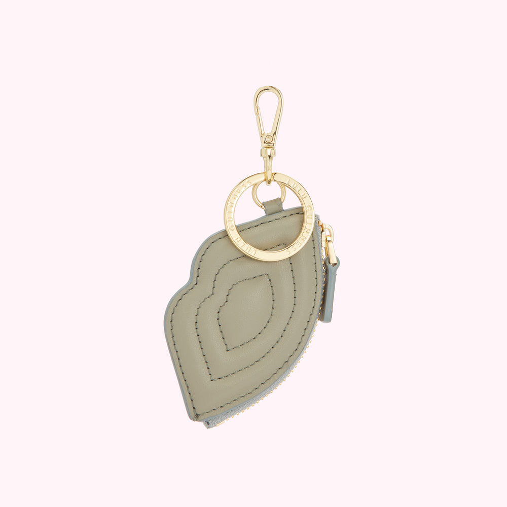 Sage green lip-shaped zipper pouch keychain with gold-toned hardware.
