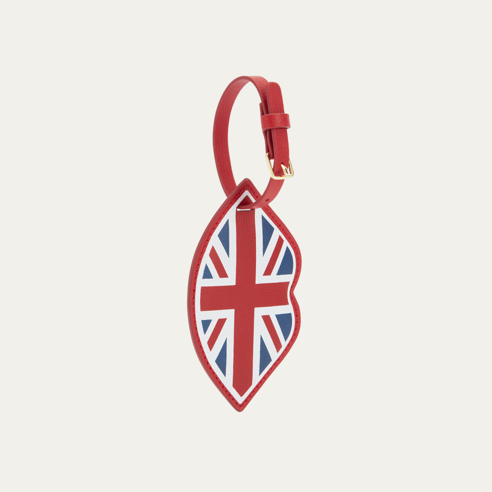 Front image of a red leather lip shaped luggage tag with buckle fastening and a  union jack print.