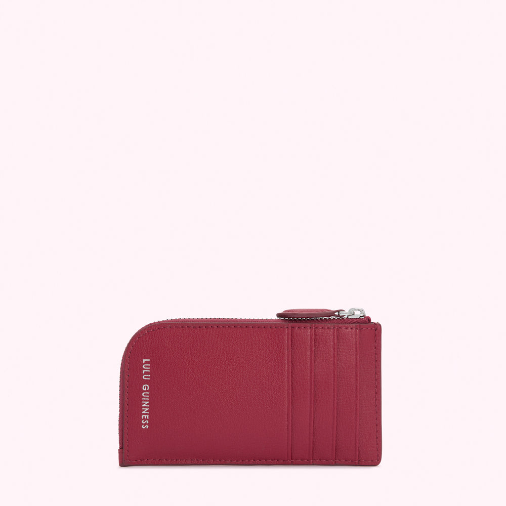 Red leather cardholder with silver zipper and Lulu Guinness logo.
