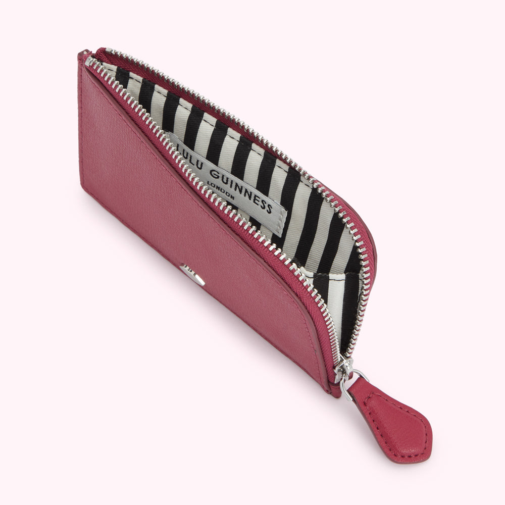 Open pink Lulu Guinness zip-around cardholder with black and white striped interior.

