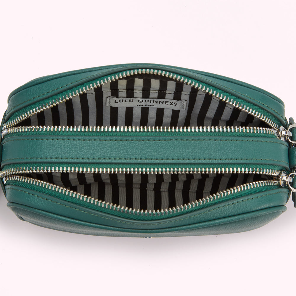 Open dark teal Lulu Guinness crossbody bag with black and white striped interior lining.
