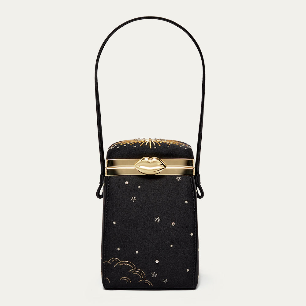 Black satin handbag with gold accents and star designs on a light gray background