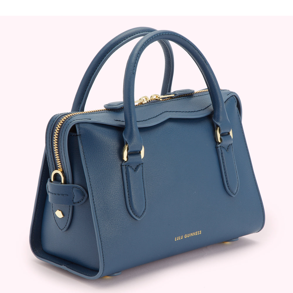 A teal blue Lulu Guinness satchel handbag with gold hardware.