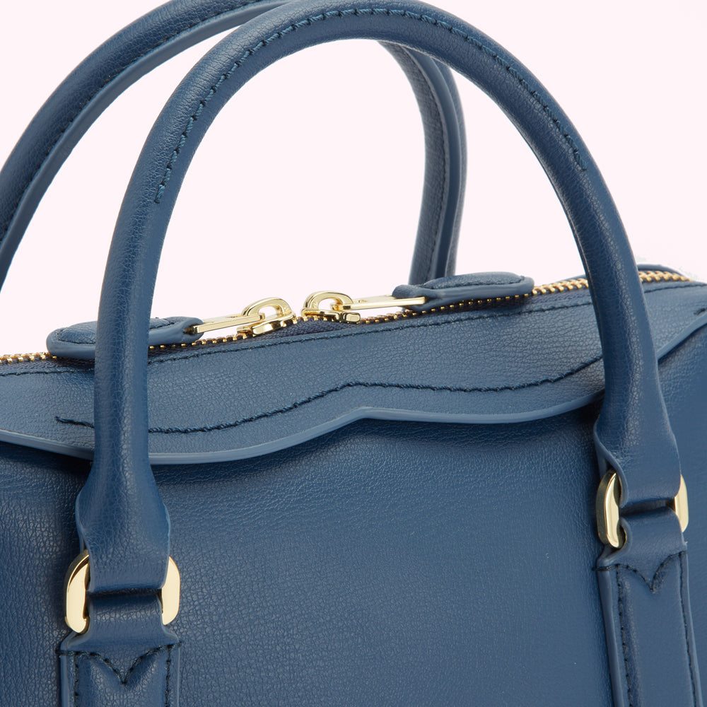 Close-up of a dark blue leather handbag with gold-toned zipper and hardware.
