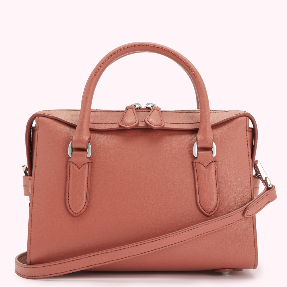 Dusty rose leather handbag with top handles and a crossbody strap.
