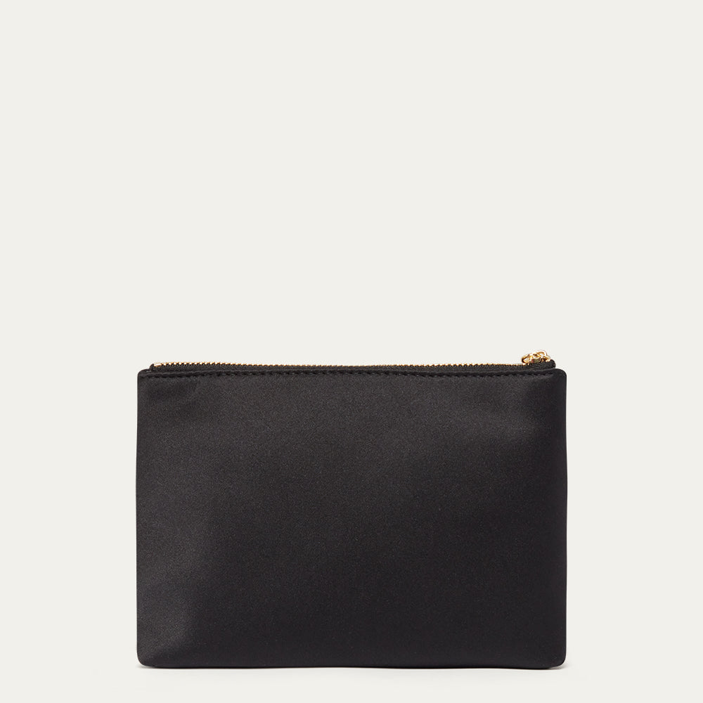 Black satin pouch with a gold zipper on a light beige background