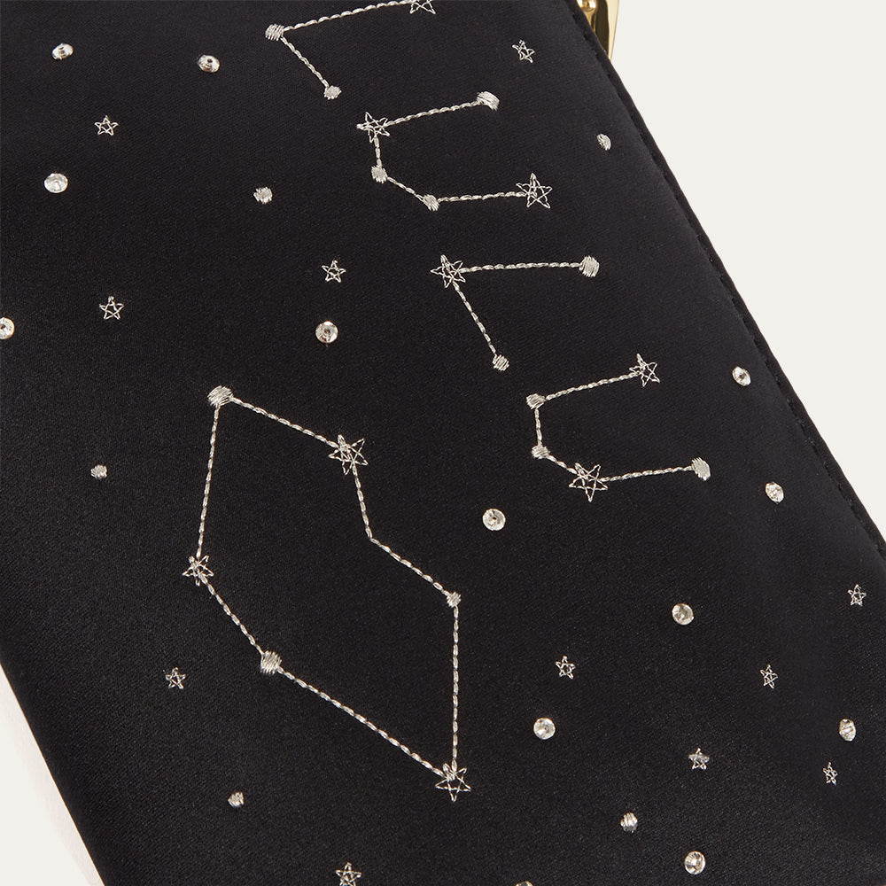 Black satin pouch with embroidered constellations and stars on a white background