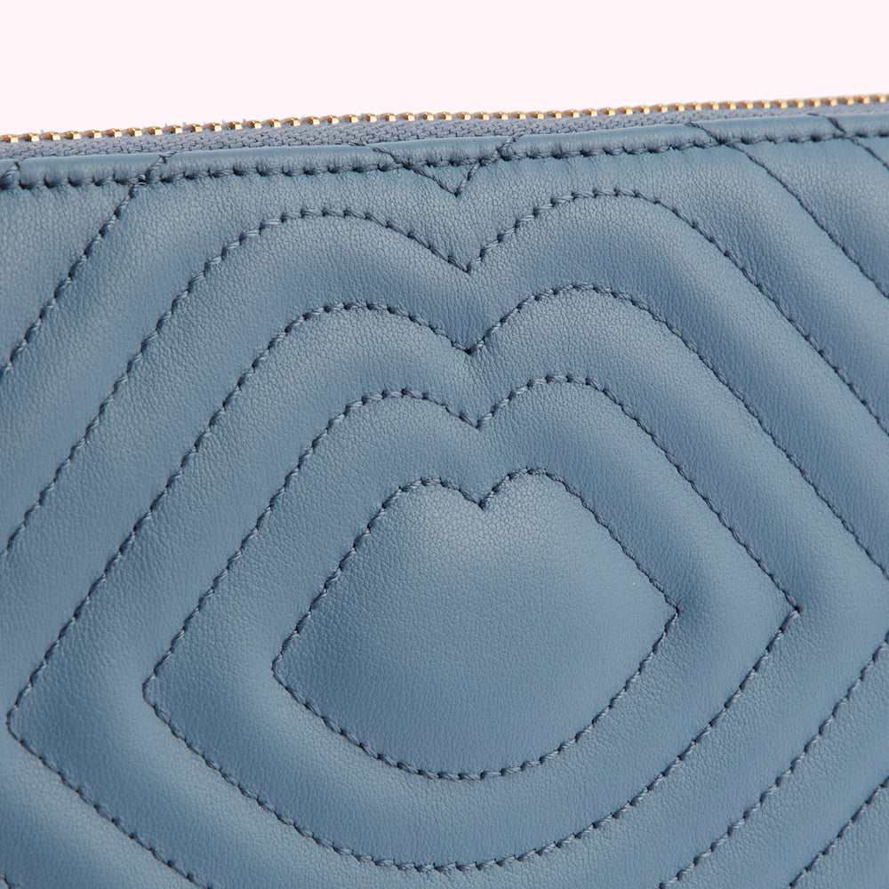 Close-up of a blue quilted leather purse with a gold zipper.
