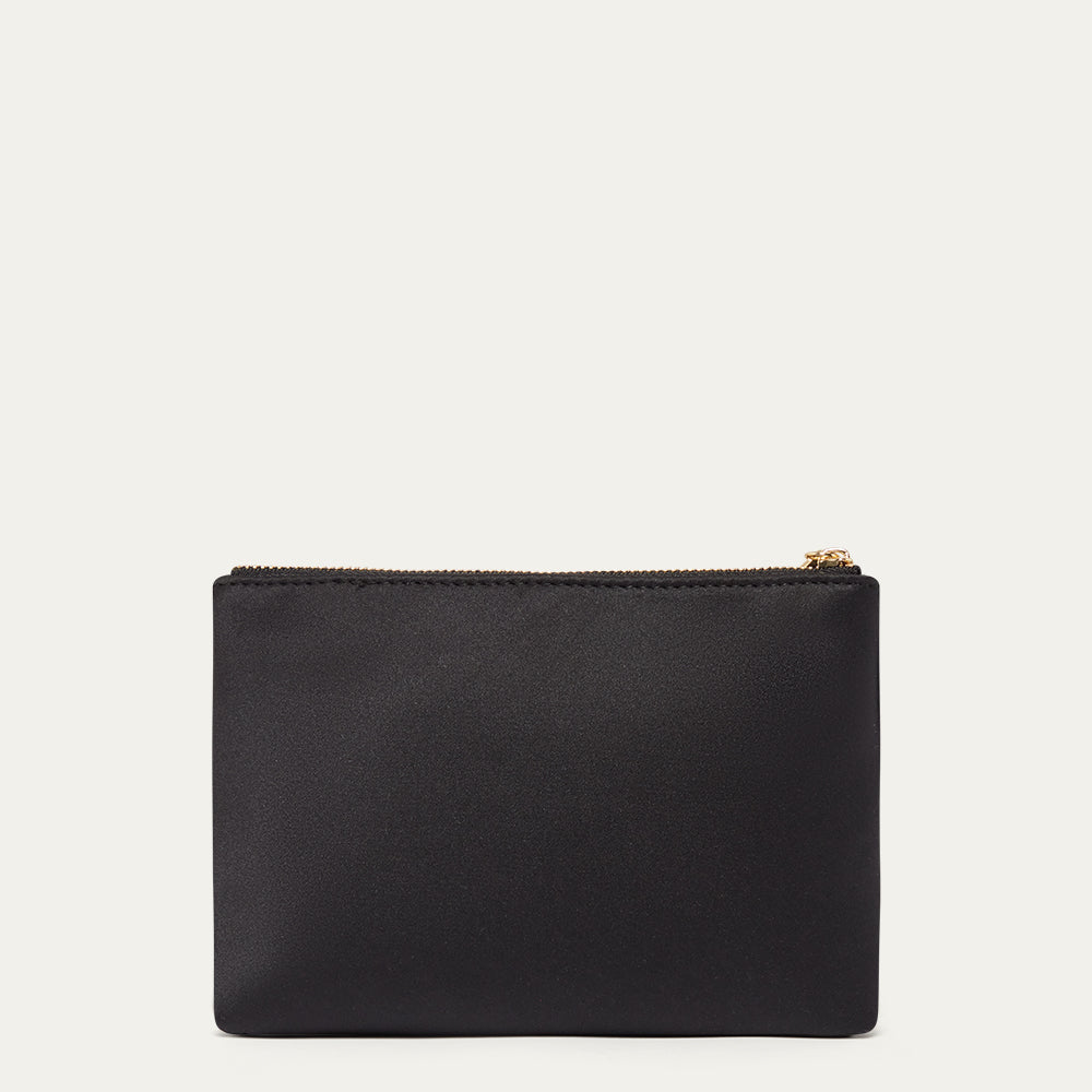 Black satin pouch with a gold zipper on a light beige background