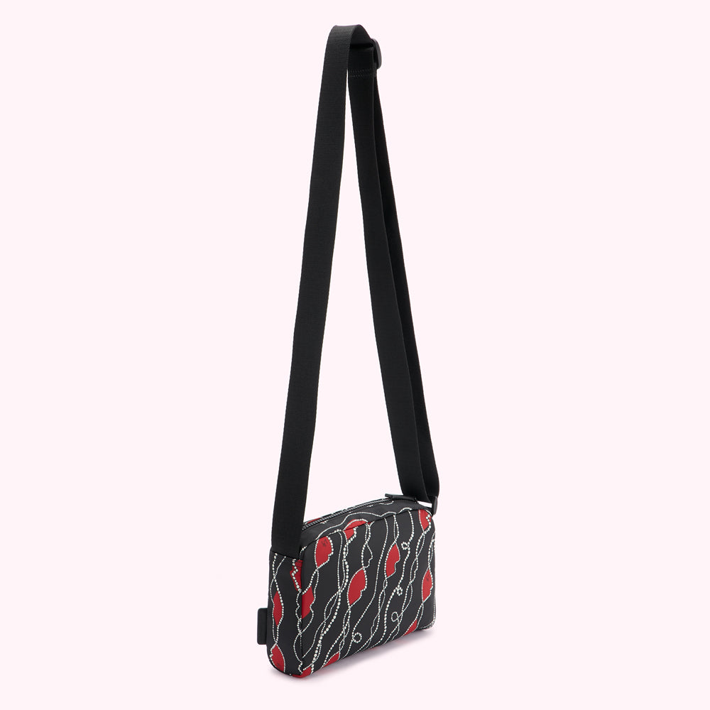 Black crossbody bag with red and white patterned design.
