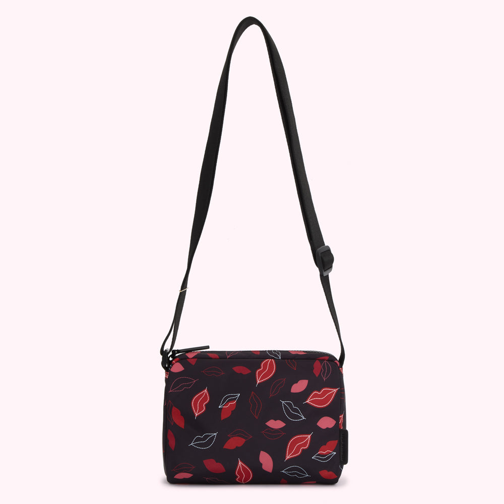 Black crossbody bag with a red and pink lip print.