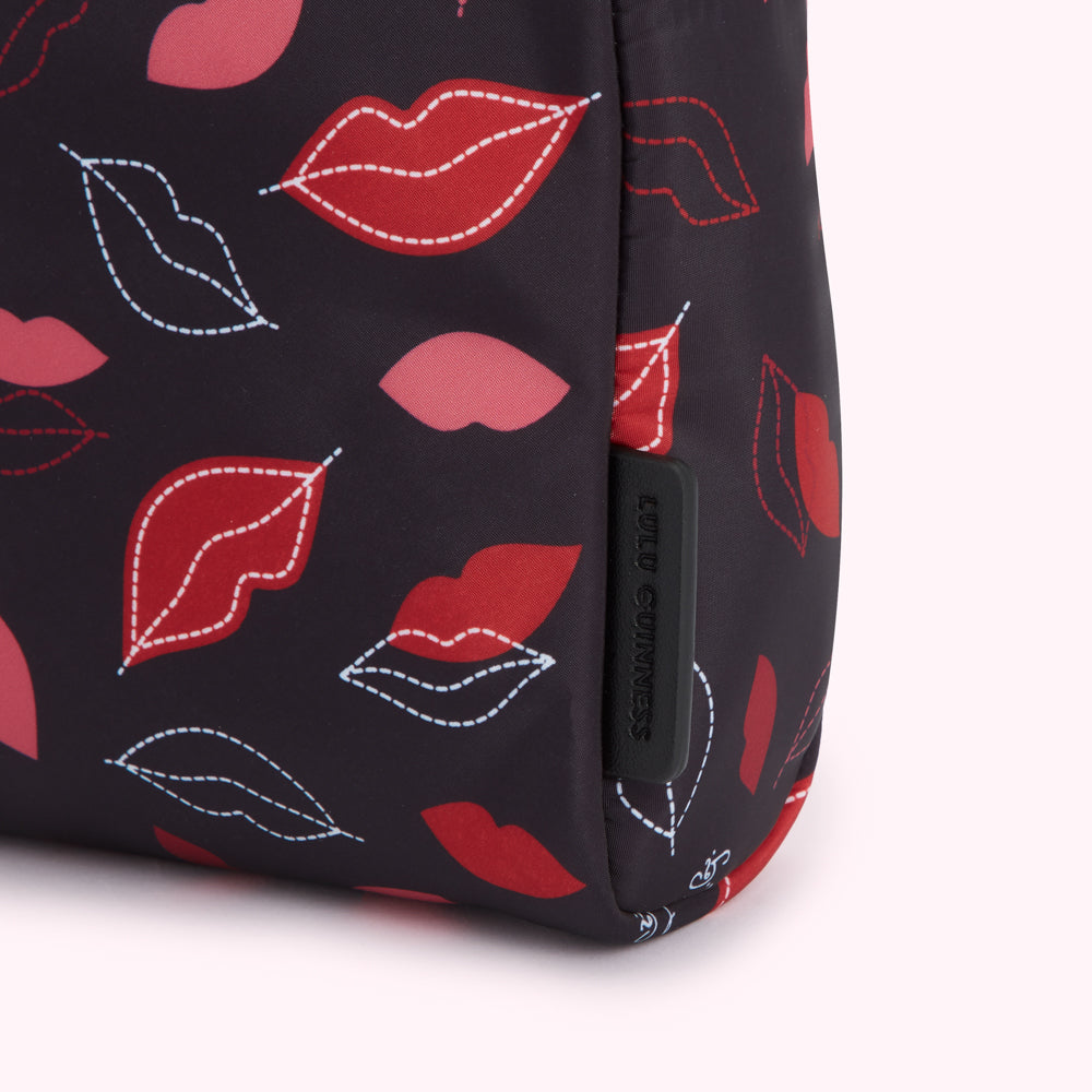 Close-up of a Lulu Guinness black wash bag with a lip print.