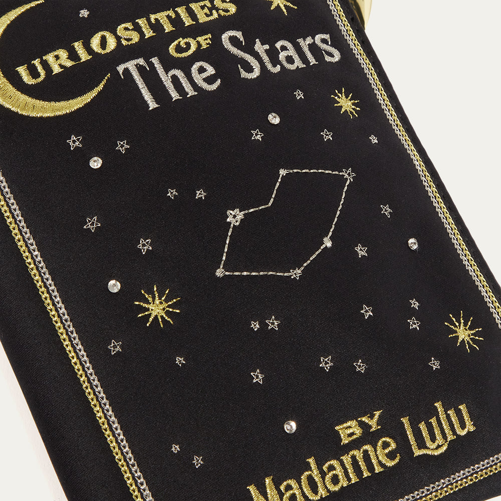 Embroidered book cover satin pouch with celestial design and 'Curiosities of the Stars' text.