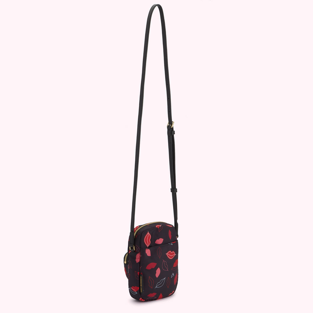 Black crossbody bag with red lips print.
