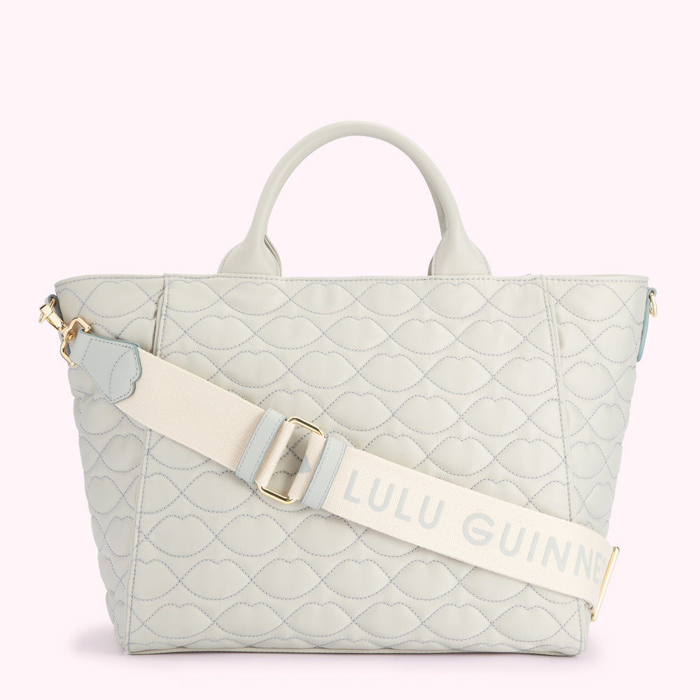 Light grey quilted tote bag with a cream-colored strap that has the Lulu Guinness logo on it.