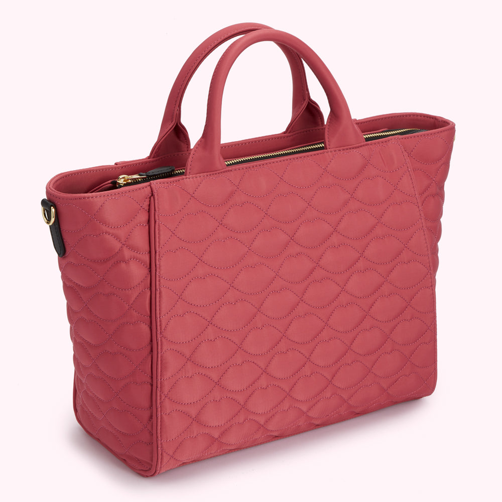 Dusty rose quilted tote bag with black handles and gold zipper.
