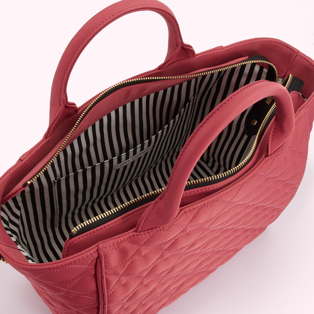 Pink quilted handbag with black and white striped interior lining.