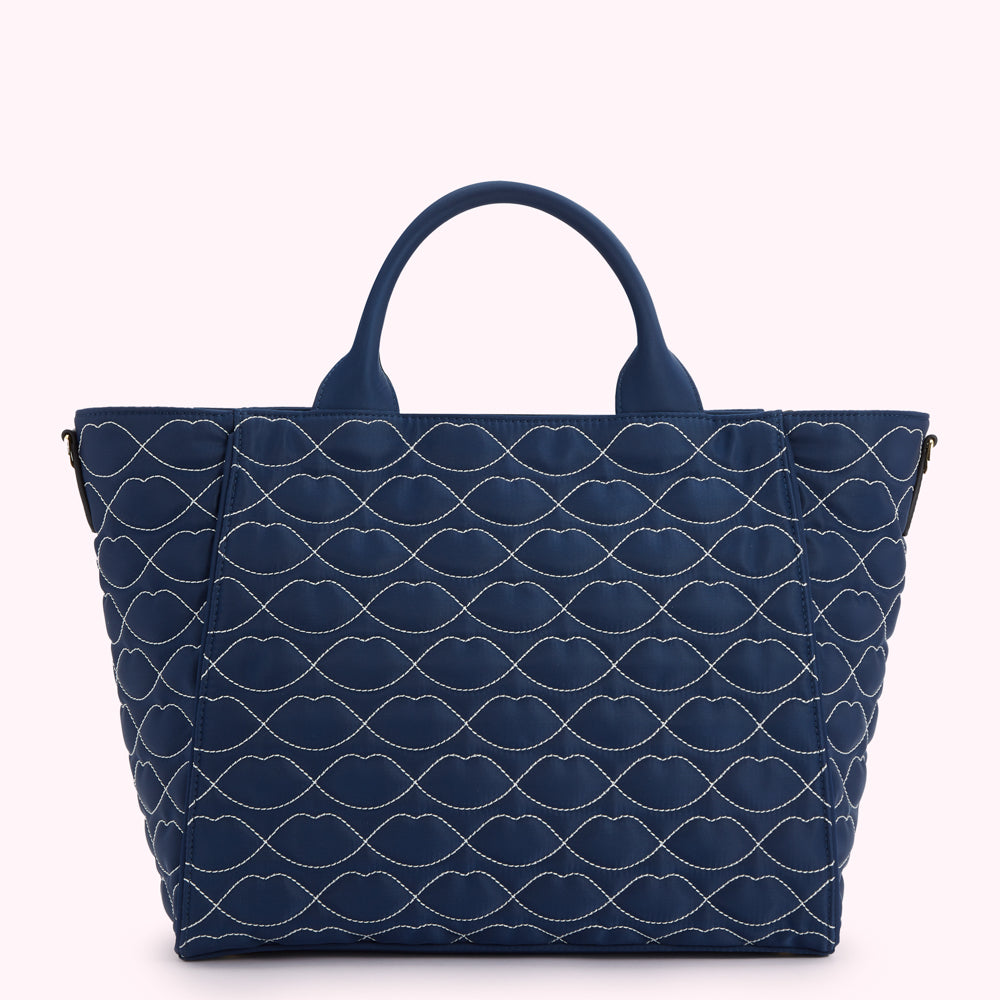 Dark blue quilted tote bag with a lip print pattern.
