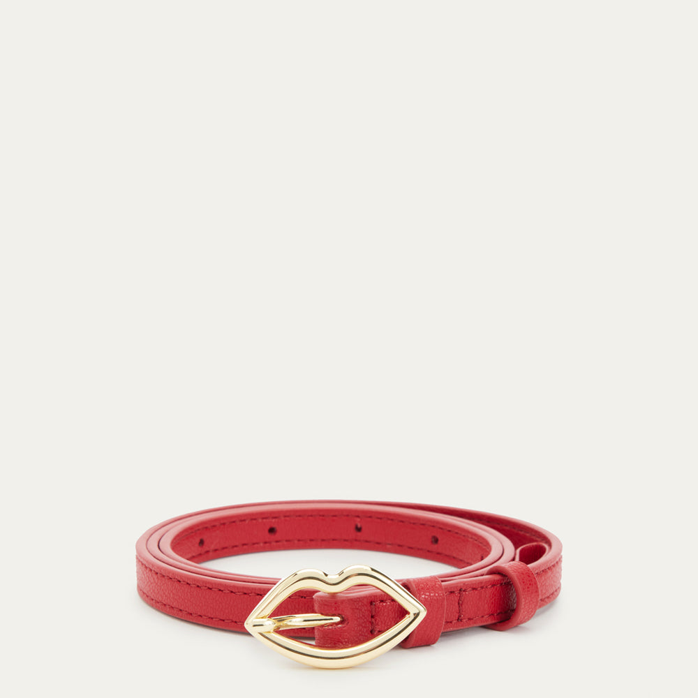 Red leather belt rolled up showing a gold lip shaped buckle.