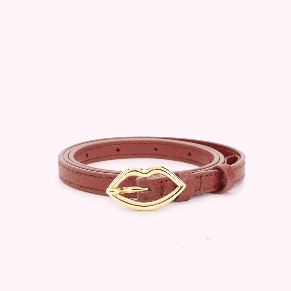 Tan brown leather belt rolled up showing a gold lip shaped buckle.