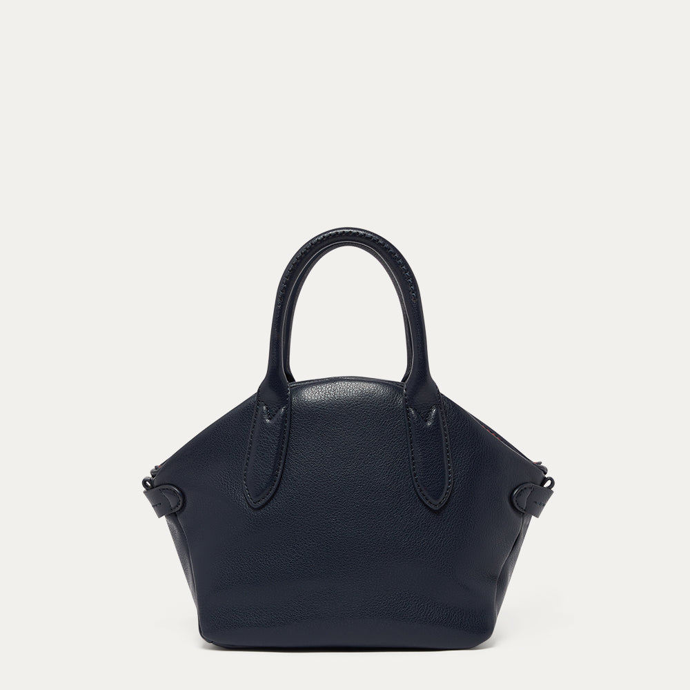 Navy leather handbag on a light gray background