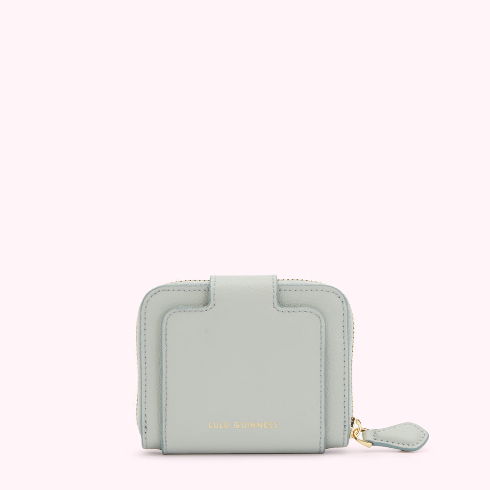 Light blue Lulu Guinness zip-around wallet against a white background.
