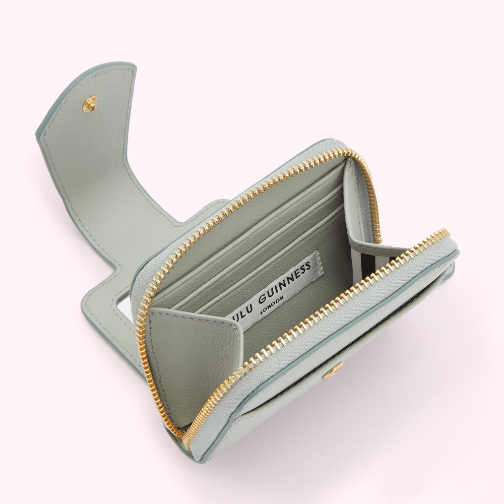 A light teal Lulu Guinness London zip-around wallet open to show the interior compartments and branding.
