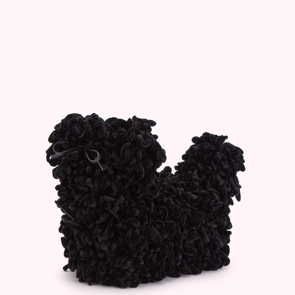 Black velvet dog-shaped bag with textured curly detailing, displayed against a light pink background