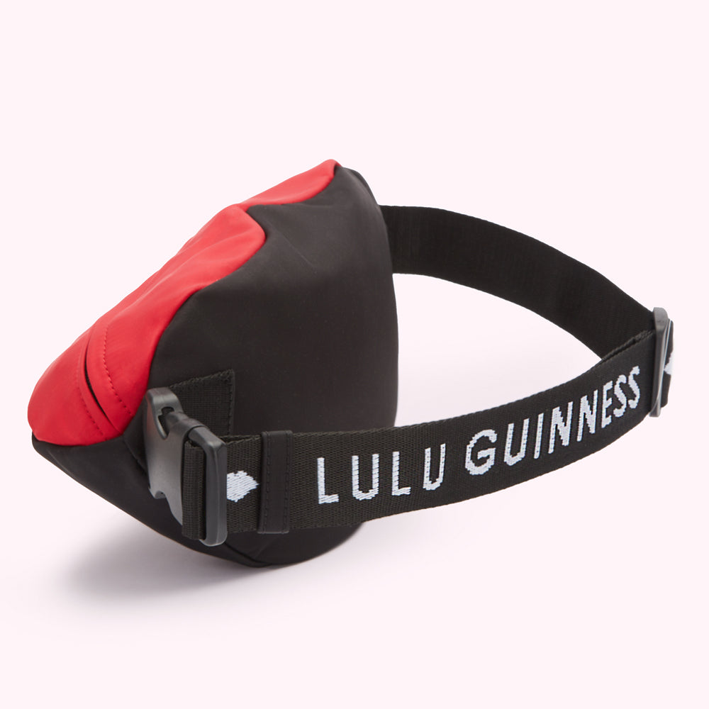 Red and black Lulu Guinness bum bag with logo on strap.

