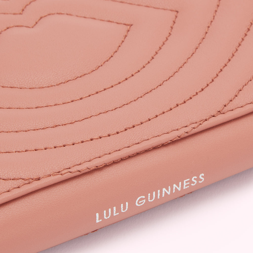 Close-up of a dusty rose Lulu Guinness wallet with quilted lips design.
