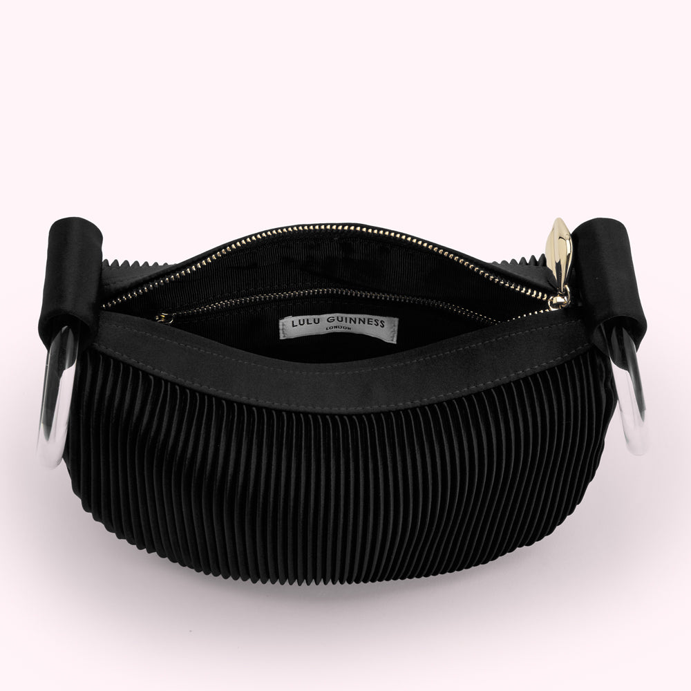 Open black pleated Lulu Guinness bag with clear handles.
