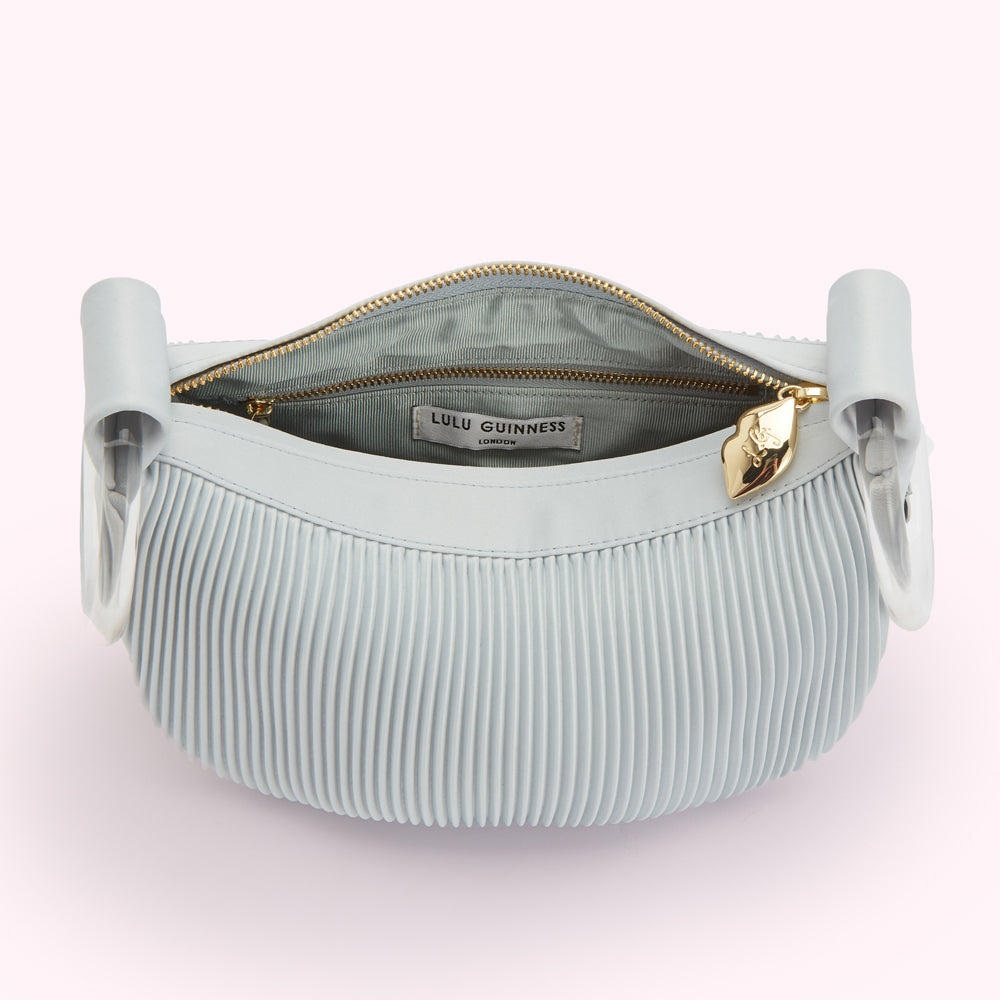 Open light blue pleated Lulu Guinness London handbag with gold zipper and logo tag.
