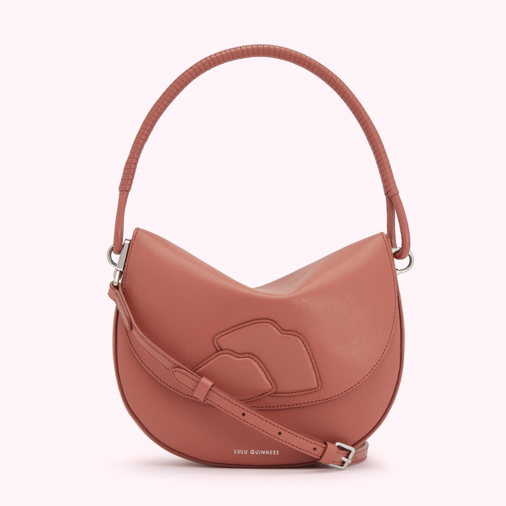 Dusty rose Lulu Guinness crescent-shaped handbag with signature lip detail and top handle.
